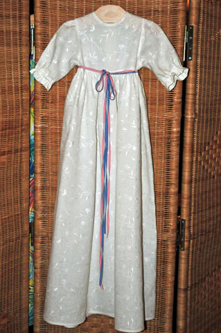 Dopkl�nning i halvblekt, broderat lintyg.